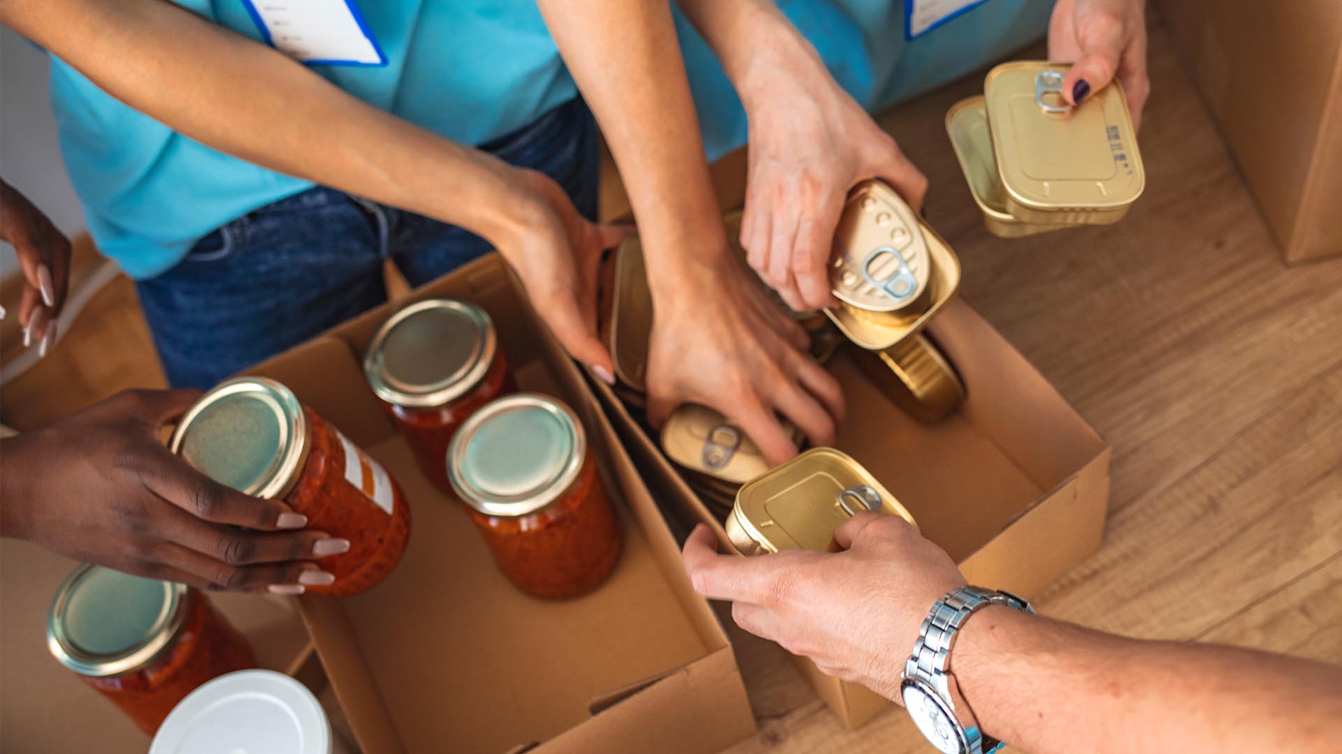 工作人員將罐頭與玻璃罐食品放入紙箱進行包裝作業的畫面 工作人員將罐頭與玻璃罐食品放入紙箱進行包裝作業的畫面