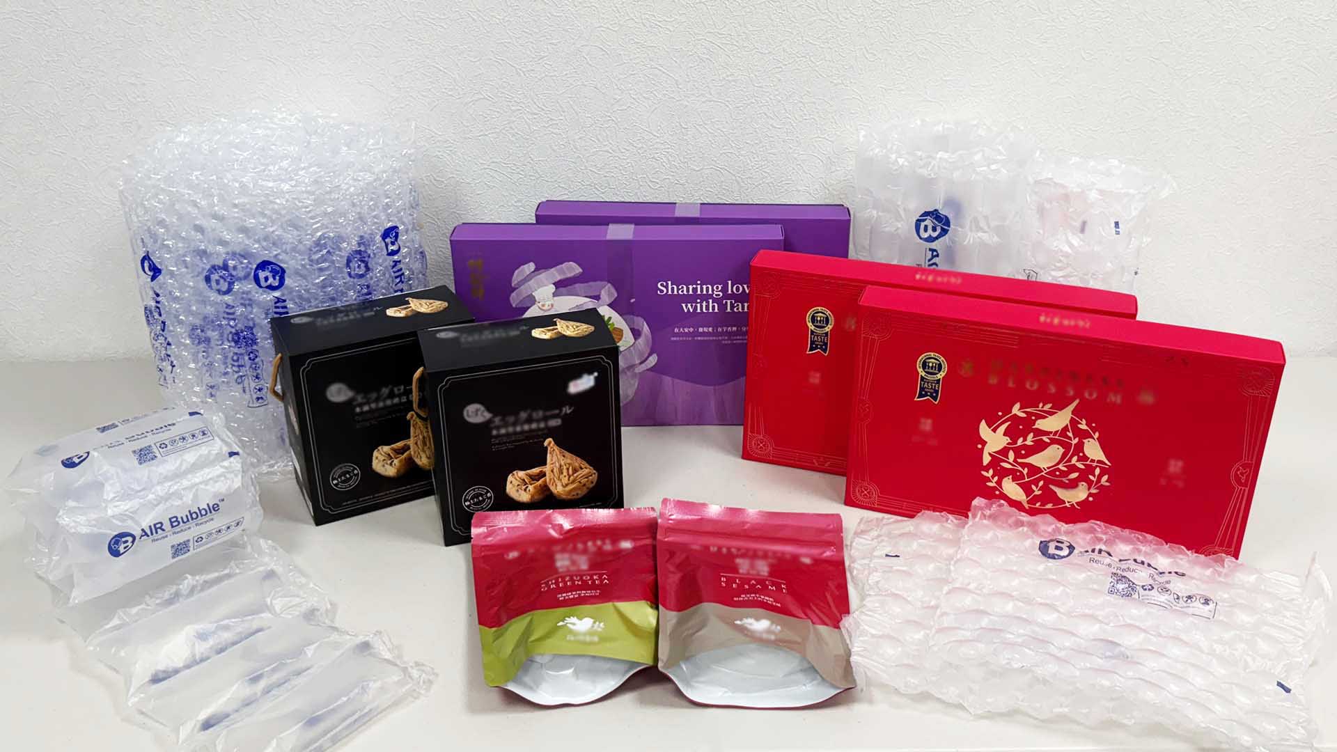 年節禮盒緩衝包裝實務示意，餅乾與伴手禮盒搭配強力氣泡布與緩衝氣墊，降低禮盒出貨破損風險，適用年節禮盒大量出貨包裝